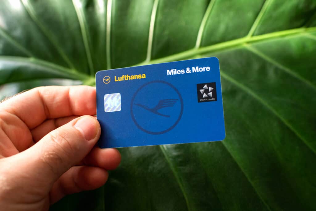 Male hand holding Miles and More membership Lufthansa card